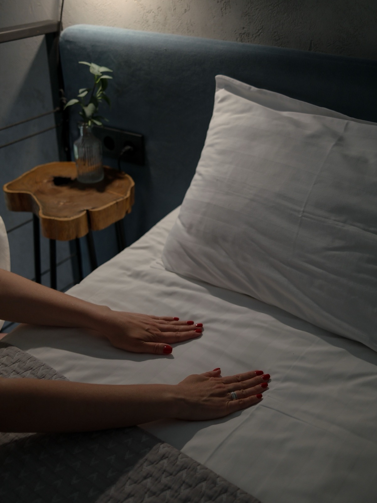 Mains préparant un lit avec un linge blanc impeccable
